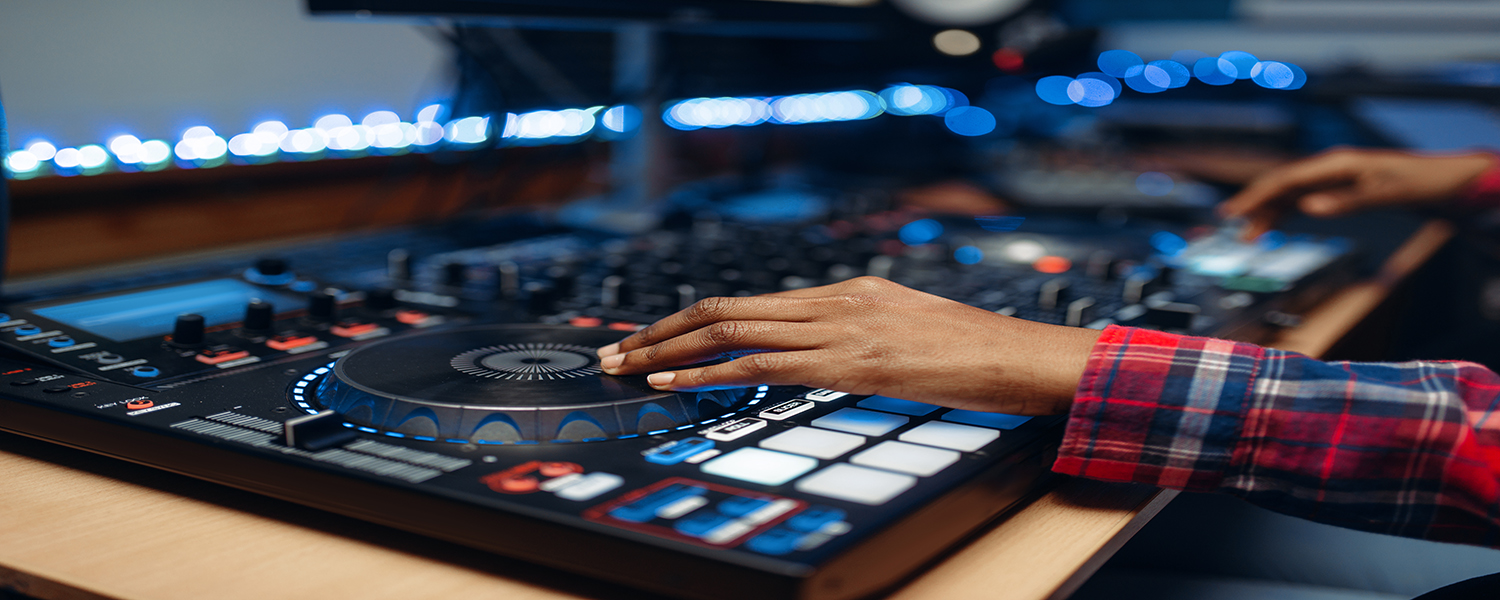 Female sound operator working at the remote control panel in audio recording studio. Musician at the mixer, professional music mixing